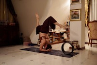 a woman doing a handstand in a living room